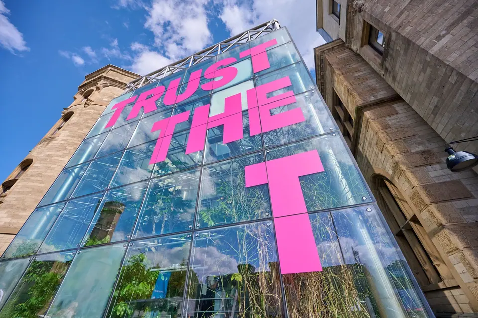 Изображение из официального пресс-релиза Deutsche Telekom: надпись «TRUST THE T» на фасаде здания